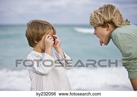 Boy taking his brother's picture with a digital camera View Large Photo Image Stock Photograph - Boy taking his brother's picture with a digital camera. Fotosearch