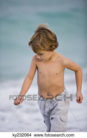 Boy walking on the beach View Large Photo Image Picture - Boy walking on the beach. Fotosearch