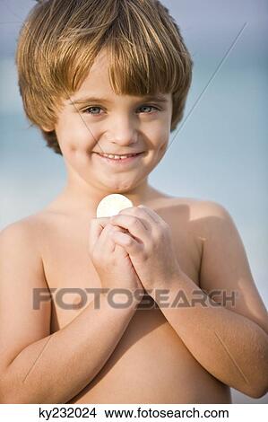Portrait of a boy holding a coin and smiling View Large Photo Image Picture - Portrait of a boy holding a coin and smiling. Fotosearch
