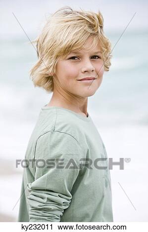 Stock Image - Portrait of a boy standing on the beach. Fotosearch