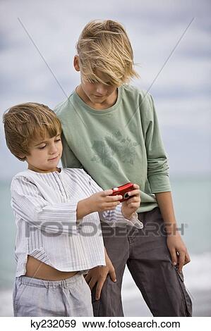 Stock Photo - Two boys looking at a camera. Fotosearch
