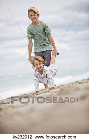 Two boys playing on the beach View Large Photo Image Stock Image - Two boys playing on the beach. Fotosearch