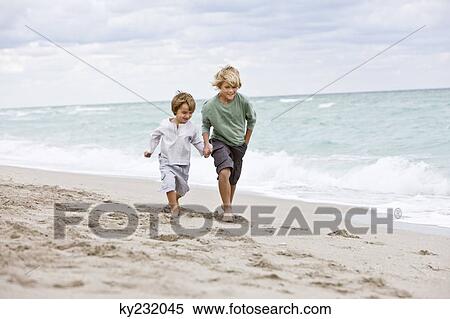 Two boys running on the beach View Large Photo Image Stock Photography - Two boys running on the beach. Fotosearch