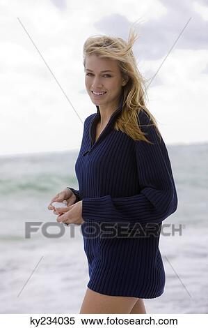 Woman holding a shell on the beach View Large Photo Image Stock Photography - Woman holding a shell on the beach. Fotosearch