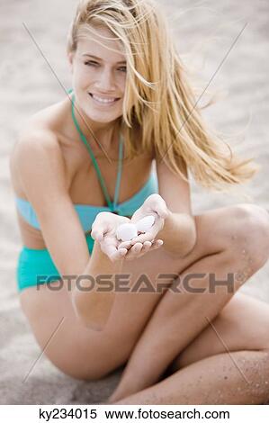 Woman holding shells on the beach View Large Photo Image Stock Photography - Woman holding shells on the beach. Fotosearch