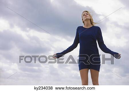 Stock Photo - Woman standing with her arm outstretched. Fotosearch