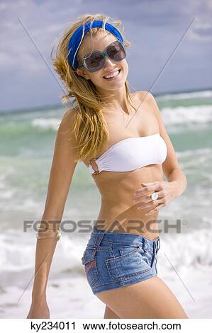Stock Image - Woman walking on the beach. Fotosearch