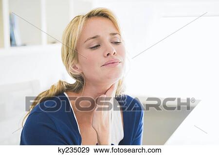 Close-up of a woman touching her throat View Large Photo Image Stock Photo - Close-up of a woman touching her throat. Fotosearch