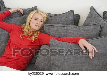 Woman reclining on a couch View Large Photo Image Stock Photo - Woman reclining on a couch. Fotosearch