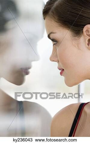 Close-up of a fashion model looking at her reflection View Large Photo Image Stock Image - Close-up of a fashion model looking at her reflection. Fotosearch