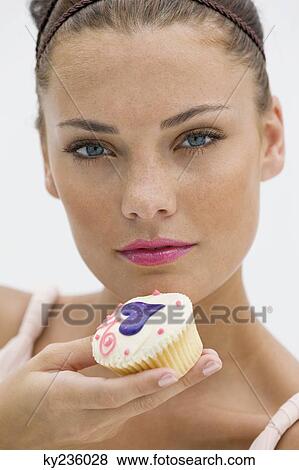 Woman holding a cupcake View Large Photo Image Stock Photo - Woman holding a cupcake. Fotosearch