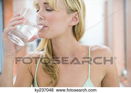 Woman drinking a glass of water View Large Photo Image Stock Photo - Woman drinking a glass of water. Fotosearch