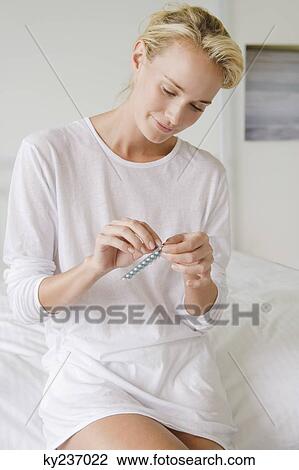 Woman holding a blister pack of medicine View Large Photo Image Stock Image - Woman holding a blister pack of medicine. Fotosearch