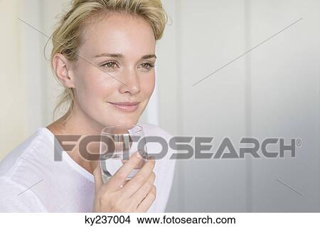 Woman holding a glass of water View Large Photo Image Picture - Woman holding a glass of water. Fotosearch