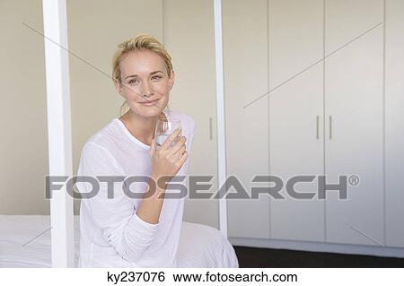 Woman holding a glass of water View Large Photo Image Stock Photograph - Woman holding a glass of water. Fotosearch