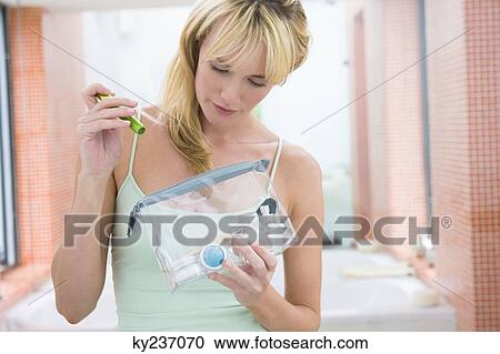 Stock Image - Woman holding a make-up bag. Fotosearch