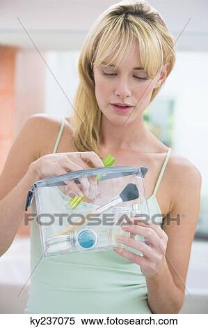 Stock Photography - Woman holding a make-up bag. Fotosearch