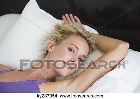 Woman lying on the bed and smiling View Large Photo Image Picture - Woman lying on the bed and smiling. Fotosearch