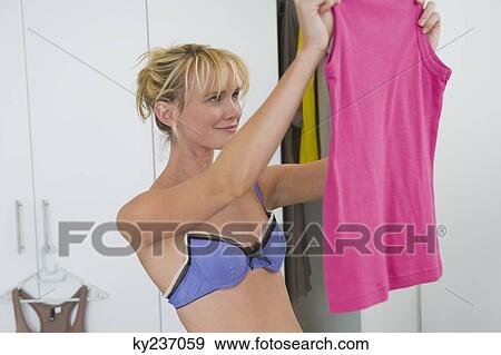 Woman selecting clothes in the bedroom View Large Photo Image Stock Photo - Woman selecting clothes in the bedroom. Fotosearch