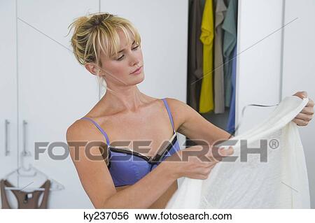 Woman selecting clothes in the bedroom View Large Photo Image Stock Photograph - Woman selecting clothes in the bedroom. Fotosearch