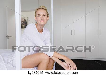Woman sitting on the bed and smiling View Large Photo Image Stock Photography - Woman sitting on the bed and smiling. Fotosearch