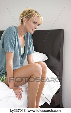 Woman sitting on the bed and thinking View Large Photo Image Stock Image - Woman sitting on the bed and thinking. Fotosearch
