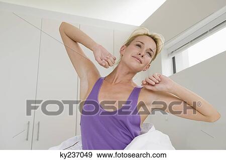 Woman stretching on the bed at morning View Large Photo Image Stock Photo - Woman stretching on the bed at morning. Fotosearch