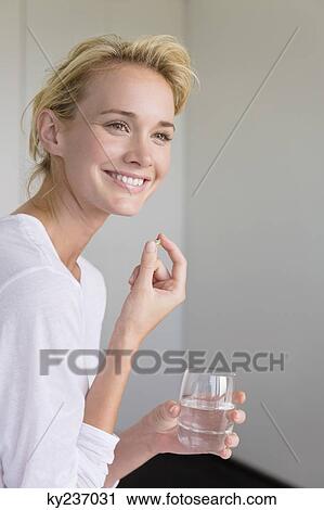 Woman taking an Omega-3 capsule View Large Photo Image Stock Image - Woman taking an Omega-3 capsule. Fotosearch