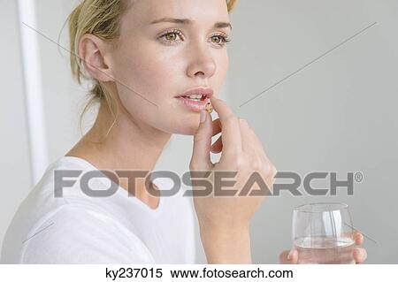 Woman taking an Omega-3 capsule View Large Photo Image Stock Photography - Woman taking an Omega-3 capsule. Fotosearch