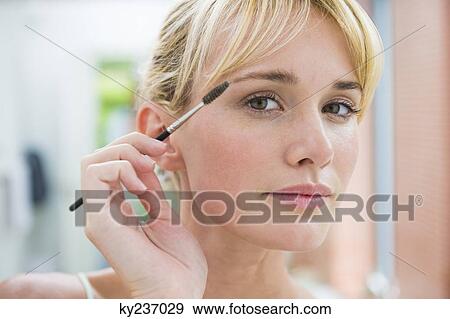 Woman using eyebrow brush View Large Photo Image Stock Photo - Woman using eyebrow brush. Fotosearch