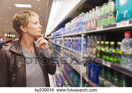 Woman buying beverages in a store View Large Photo Image Stock Photograph - Woman buying beverages in a store. Fotosearch