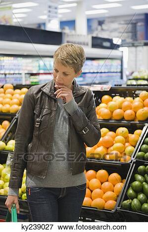 Woman buying fruits in a supermarket View Large Photo Image Stock Photo - Woman buying fruits in a supermarket. Fotosearch