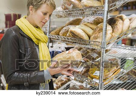 Woman choosing breads in a supermarket View Large Photo Image Picture - Woman choosing breads in a supermarket. Fotosearch