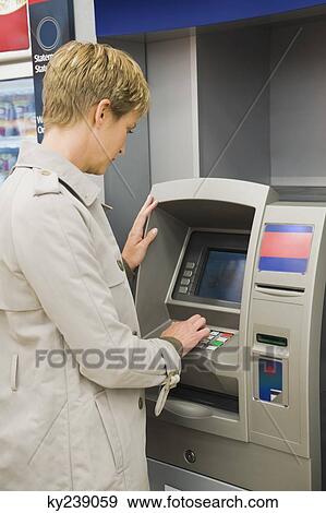 Woman entering pin number in an ATM View Large Photo Image Stock Photo - Woman entering pin number in an ATM. Fotosearch