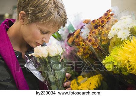 Woman holding a bouquet of flowers in a florist shop View Large Photo Image Picture - Woman holding a bouquet of flowers in a florist shop. Fotosearch