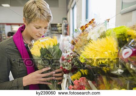 Woman holding a bouquet of flowers in a florist shop View Large Photo Image Stock Image - Woman holding a bouquet of flowers in a florist shop. Fotosearch