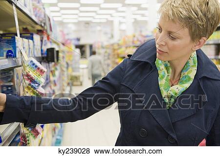 Woman shopping in a supermarket View Large Photo Image Stock Photo - Woman shopping in a supermarket. Fotosearch