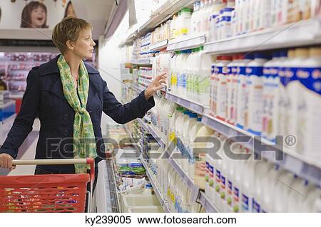 Woman shopping in a supermarket View Large Photo Image Stock Photography - Woman shopping in a supermarket. Fotosearch