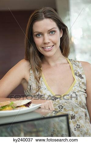Woman eating sandwich in a cafe View Large Photo Image Stock Photo - Woman eating sandwich in a cafe. Fotosearch