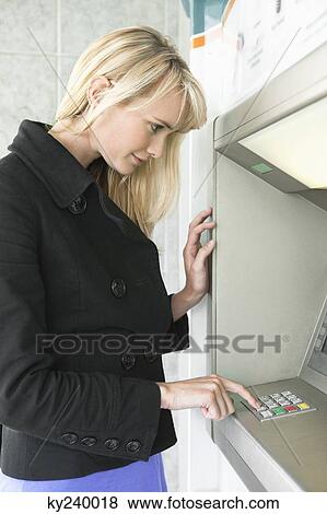 Woman entering pin number in an ATM View Large Photo Image Stock Photo - Woman entering pin number in an ATM. Fotosearch