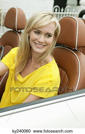 Woman sitting in a car and smiling View Large Photo Image Stock Image - Woman sitting in a car and smiling. Fotosearch