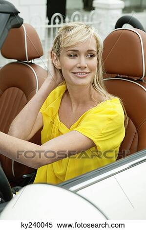 Woman sitting in a car and smiling View Large Photo Image Stock Photography - Woman sitting in a car and smiling. Fotosearch