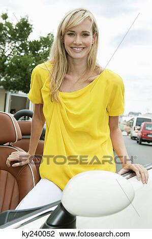 Woman smiling near a car after shopping View Large Photo Image Stock Image - Woman smiling near a car after shopping. Fotosearch
