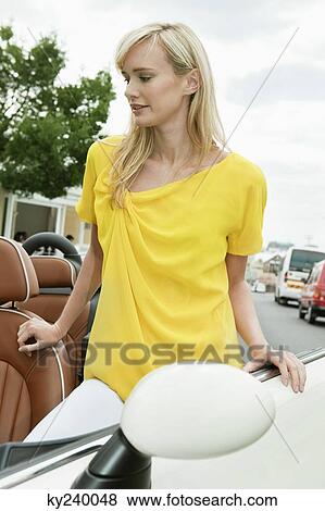 Woman standing near a car after shopping View Large Photo Image Stock Photo - Woman standing near a car after shopping. Fotosearch