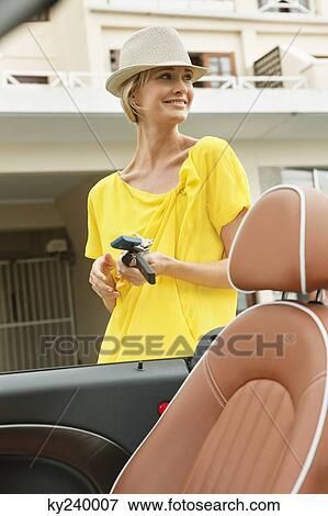 Woman standing near a car and smiling View Large Photo Image Stock Photo - Woman standing near a car and smiling. Fotosearch