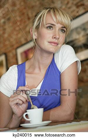 Woman stirring coffee in a cafe View Large Photo Image Stock Photography - Woman stirring coffee in a cafe. Fotosearch