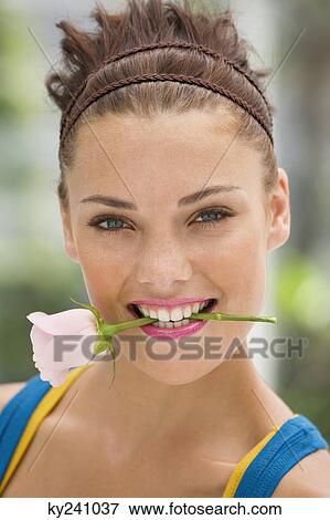 Fashion model holding rose between her teeth View Large Photo Image Stock Photo - Fashion model holding rose between her teeth. Fotosearch