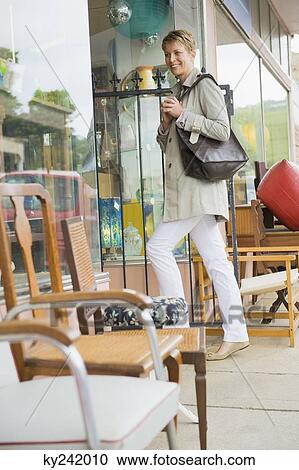 Stock Image - Woman entering in a store. Fotosearch
