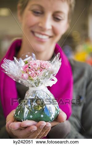 Woman holding a bouquet of flowers and smiling View Large Photo Image Stock Image - Woman holding a bouquet of flowers and smiling. Fotosearch