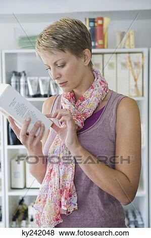 Woman holding a container in a store View Large Photo Image Stock Photo - Woman holding a container in a store. Fotosearch